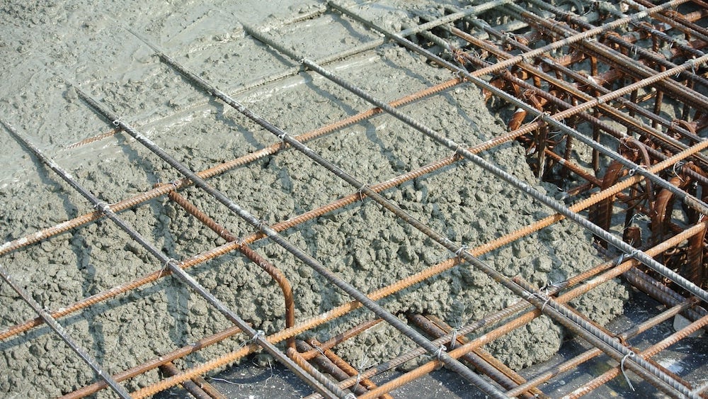 wet concrete is poured on a steel reinforcement to form strong floor slabs