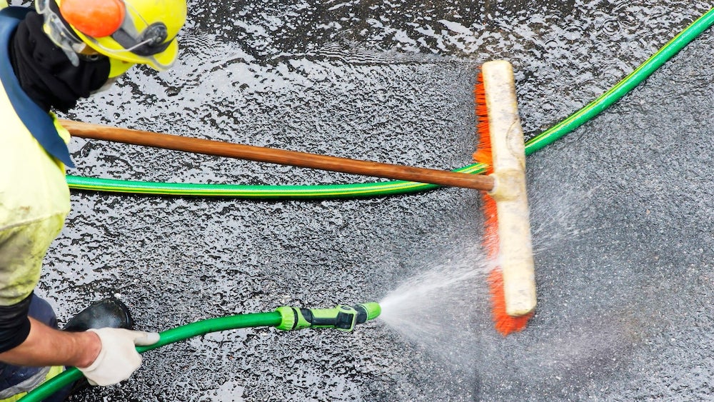 a worker cleans with water pressure at a construction site